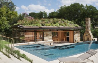 O piscină modernă pune în valoare o cabană din lemn și sticlă cu un acoperiș plin de flori sălbatice